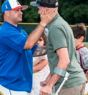 Founder Bobby Glennerster Jr. embracing a supporter on the field