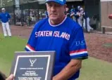 Coach holding an award plaque
